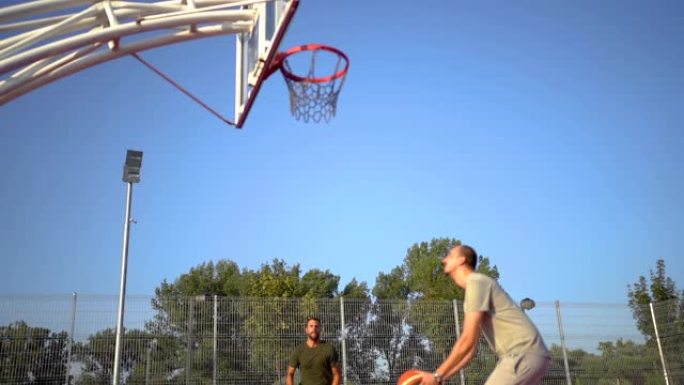 两个朋友在户外球场上打篮球