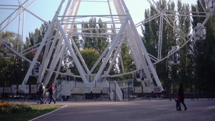 在公园里，一个大型摩天轮正在缓慢旋转。高空观察轮