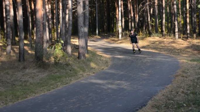 一个人在森林里的一条柏油路上溜旱冰。