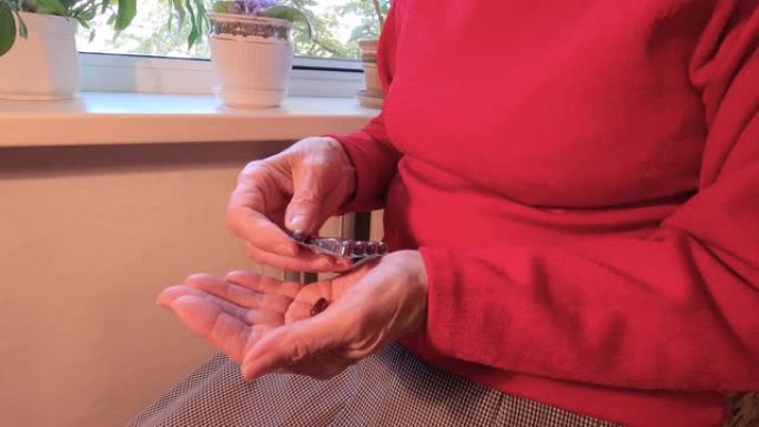 老年成年妇女手持止痛药，将两粒胶囊从meds瓶中取出，老年祖母保健，药房和治疗理念，特写