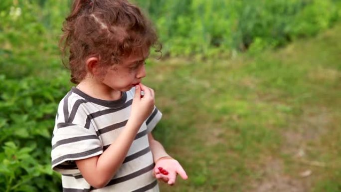 沉思的小女孩在后院吃浆果