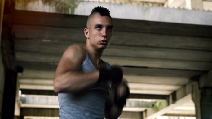 英俊的肌肉发达的年轻人戴着拳击手套。力量和动力