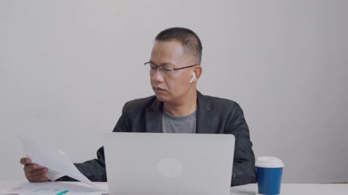 亚裔商人正在将营销统计数据纳入在线计算机系统。