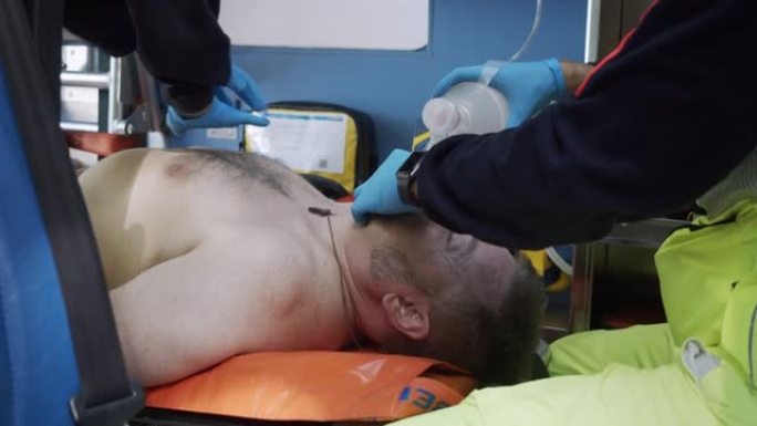 医护人员在救护车内帮助一名携带Ambu包的男子时的慢动作视频