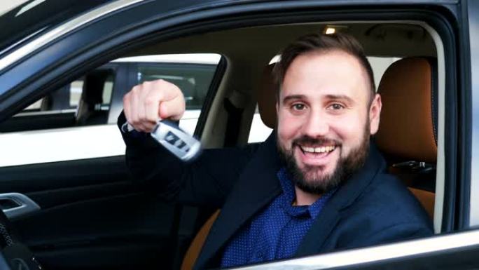 一名男子坐在他的新车上，对着镜头微笑，向他展示了他新买的车的车钥匙