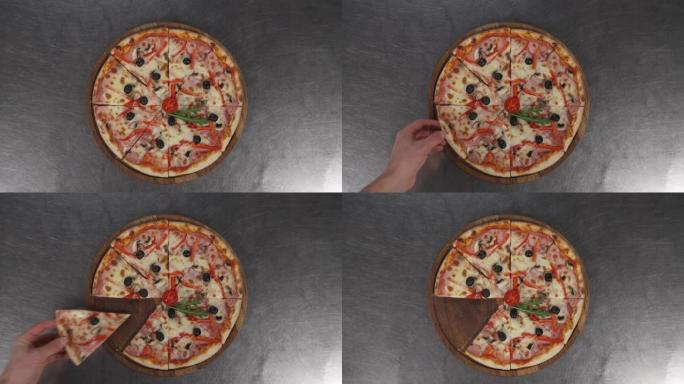 一只手拍一片新鲜出炉的披萨的特写镜头。男人拿一块披萨配奶酪、西红柿和火腿。美味的食物，供饕餮和享受。