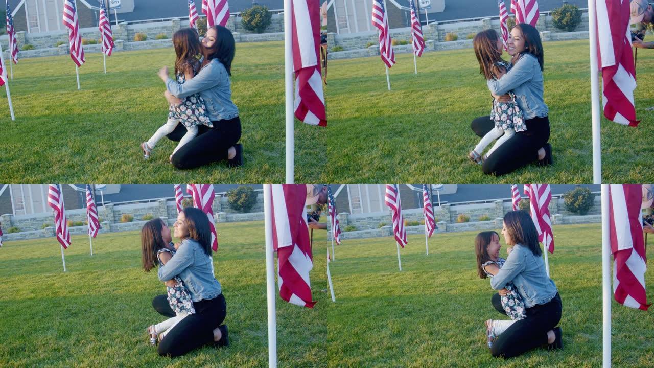 四岁的西班牙裔女孩穿着印花连衣裙，在公园里奔跑，美国国旗跪在她三十岁母亲的怀抱中，黄昏时拥抱在外面