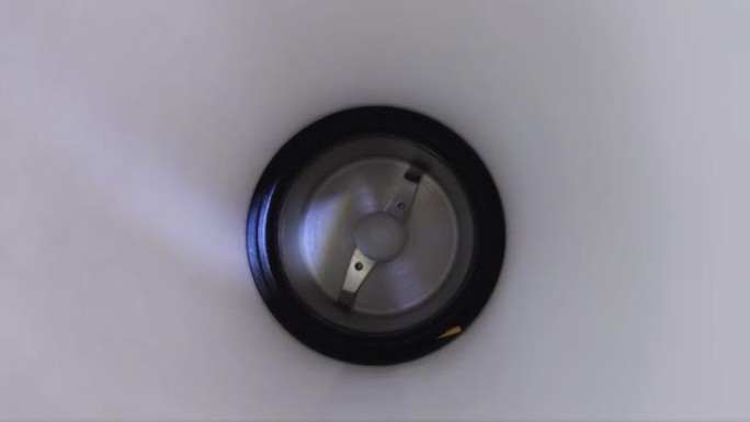 电动咖啡研磨机的刀片被光束击中的特写视频。咖啡师工作和煮咖啡的概念。