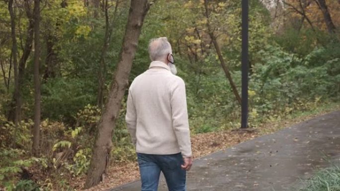 戴面具的大胡子老人在公园散步。一个人
