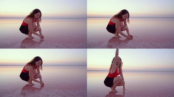 女人从乌克兰的粉红色盐湖泼水