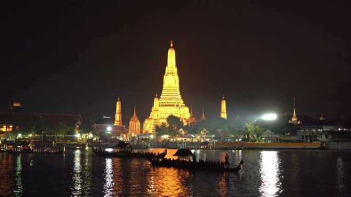 黎明神庙Wat Arun，与泰国国王在泰国曼谷市中心附近的湄南河上的皇家驳船游行。泰国建筑背景。大型