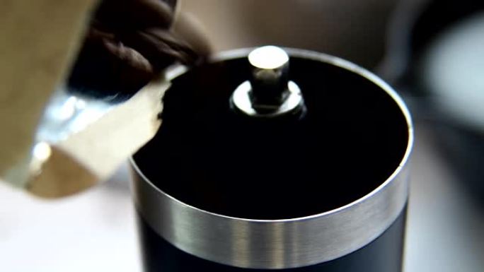 在家做滴咖啡，烤咖啡豆倒入咖啡研磨机。特写。
