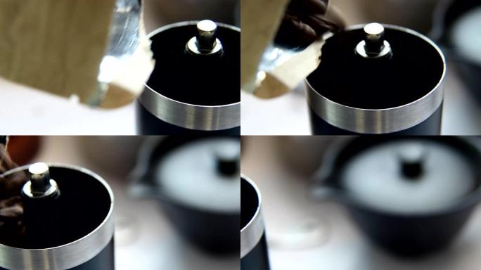 在家做滴咖啡，烤咖啡豆倒入咖啡研磨机。特写。