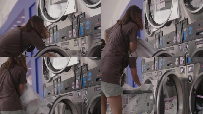 年轻女子正在自动洗衣店洗衣服。