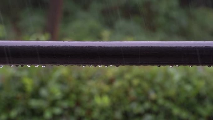 雨滴落在阳台栏杆上，并在大雷雨中滑落