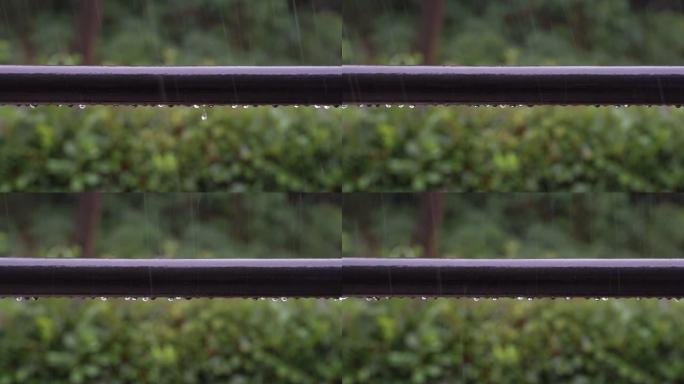 雨滴落在阳台栏杆上，并在大雷雨中滑落