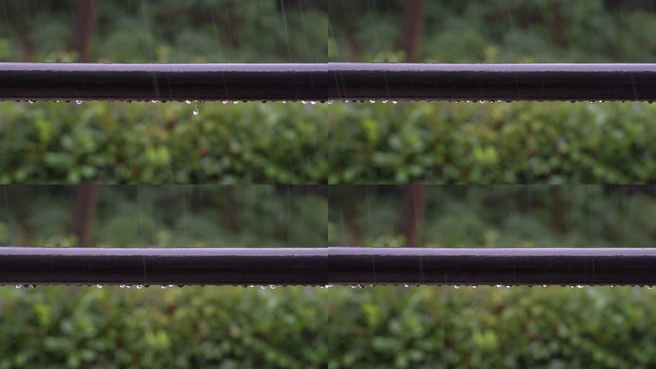 雨滴落在阳台栏杆上，并在大雷雨中滑落