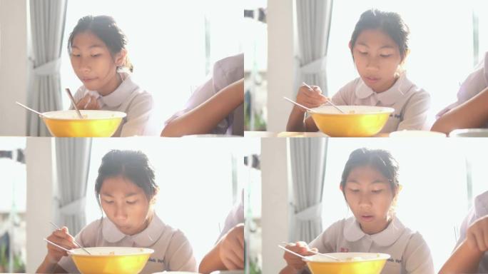 亚洲学童上学前在家一起吃早餐。