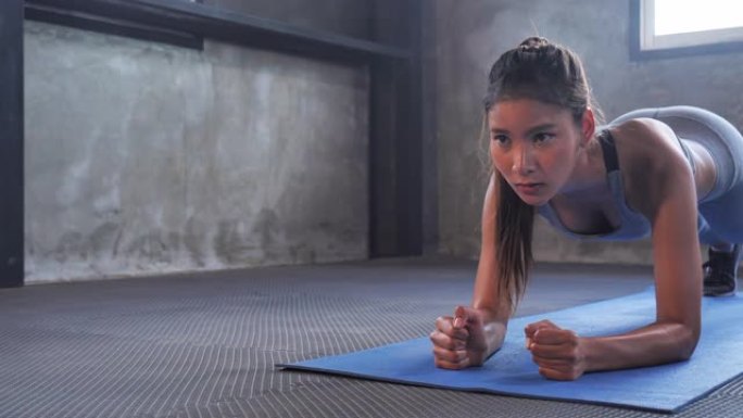 年轻的运动女性在健身房积极练习，女运动员在健身房训练。