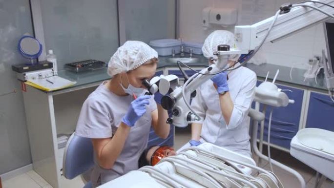 一位女性专家正在做牙齿治疗。她正在使用显微镜。牙髓医生正在治疗运河。