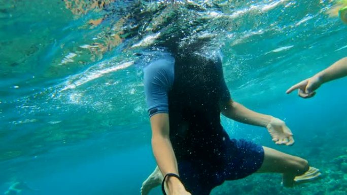 父亲和儿子在印度尼西亚努沙佩尼达岛的水晶湾海滩的湛蓝水中浮潜