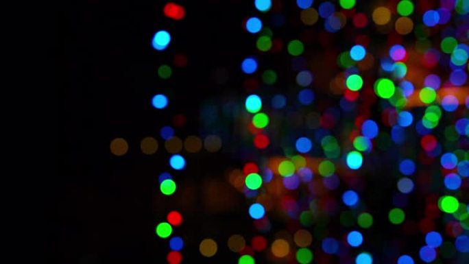 新年/圣诞节的4k镜头未聚焦模糊的闪光灯garland在黑暗中。寒假艺术资源概念视频。
