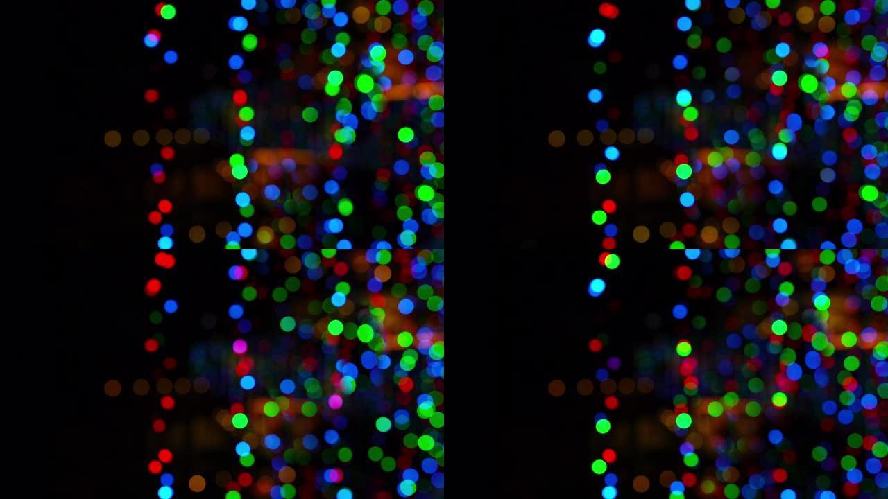新年/圣诞节的4k镜头未聚焦模糊的闪光灯garland在黑暗中。寒假艺术资源概念视频。