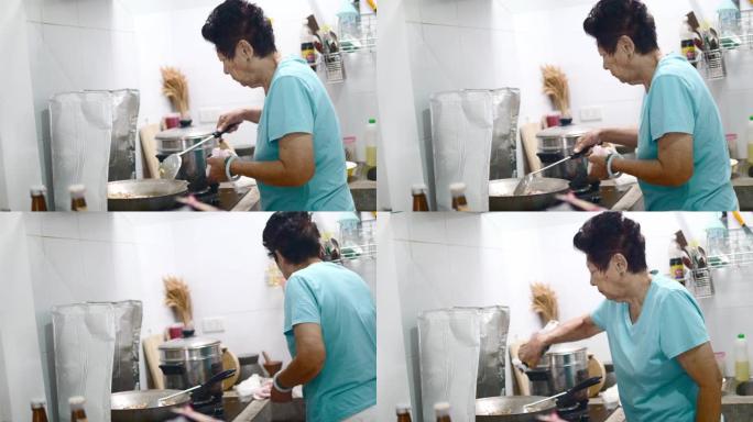 亚洲高级女性在厨房为家庭做饭，生活方式理念。