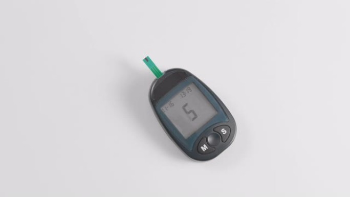 一个无法识别的人用血糖仪测量血糖。挤一滴血，然后进行单条测试。测量6.2 mmol。糖尿病的概念预防