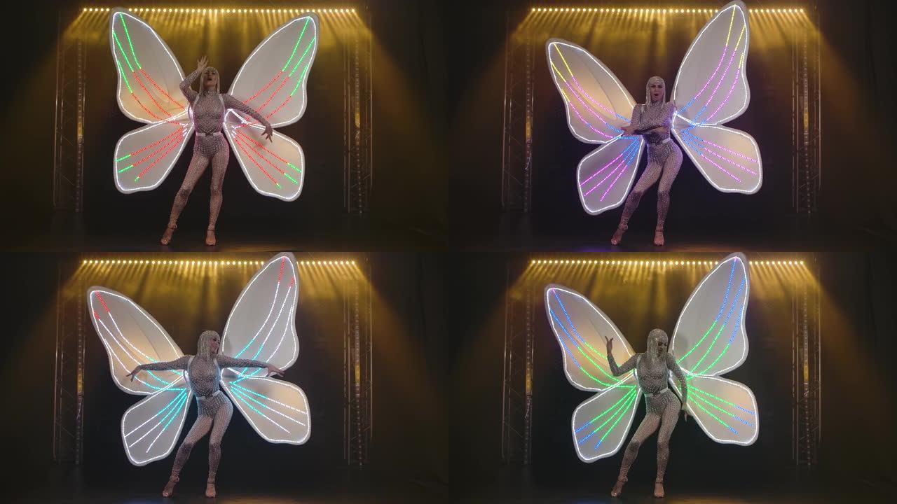 一位迷人的女人，呈蝴蝶的形式，背后是白色的翅膀，在舞台上唱歌。慢动作
