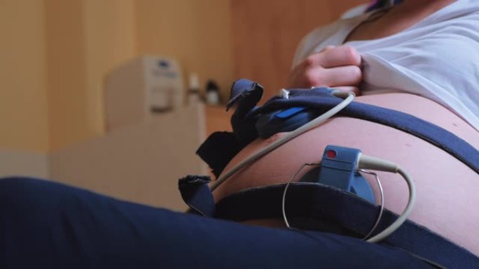 孕妇深呼吸，胎儿监护仪绑在腹部