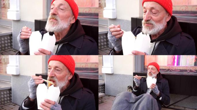 老年流浪汉坐在步行街上，饥渴地吃东西