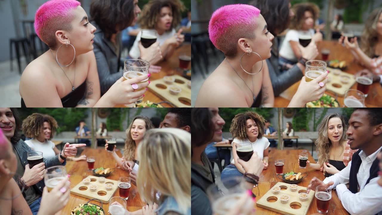 粉红色短发的女人在酒吧和朋友一起喝啤酒