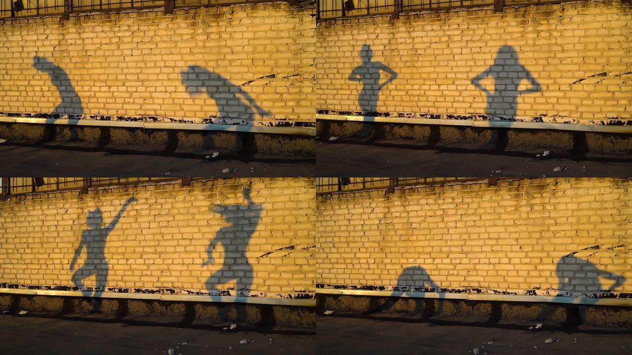 夏季日落时，舞者在砖墙上的剪影