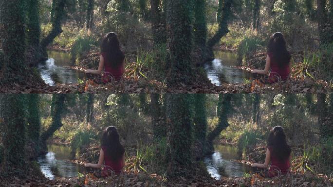 4k视频，成年女性在丛林中通过流水进行瑜伽练习
