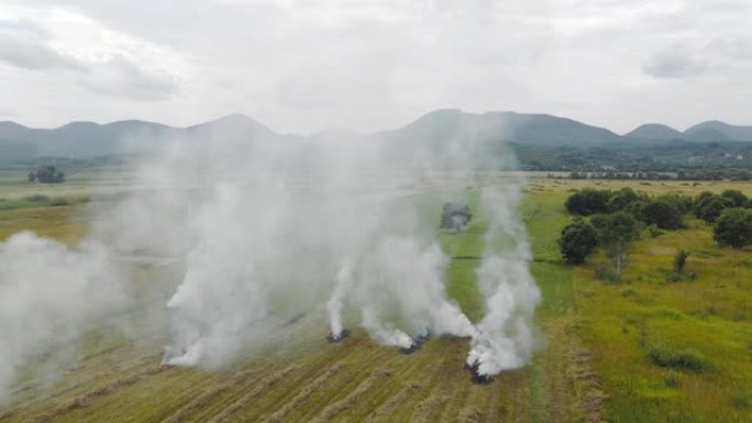 空中飞行的人在田里烧干草。在田野里开火，飞越烟雾弥漫的田野。
