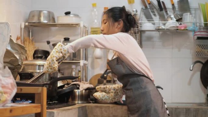 亚洲女孩穿着围裙和手手套在家自己做薯条前，生活方式理念。
