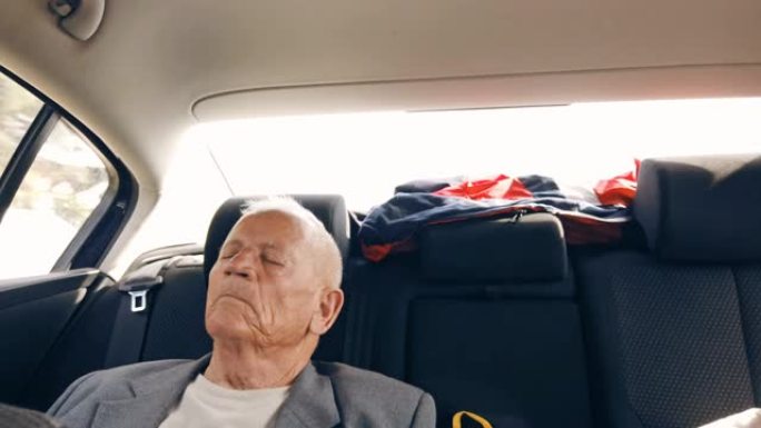 一位老人正坐在后座上睡觉