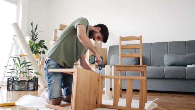 男子在家组装家具，用蓄能器螺丝刀组装椅子