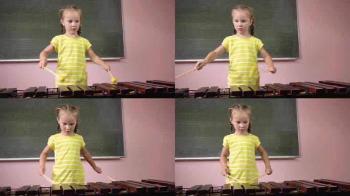 一个小女孩在音乐课上演奏木琴。4k