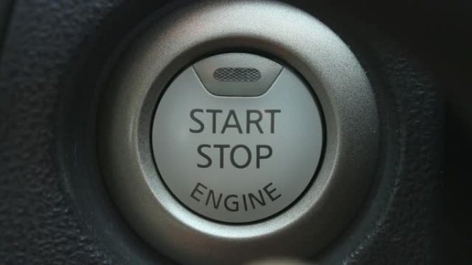 汽车中手指按下启动发动机按钮的特写