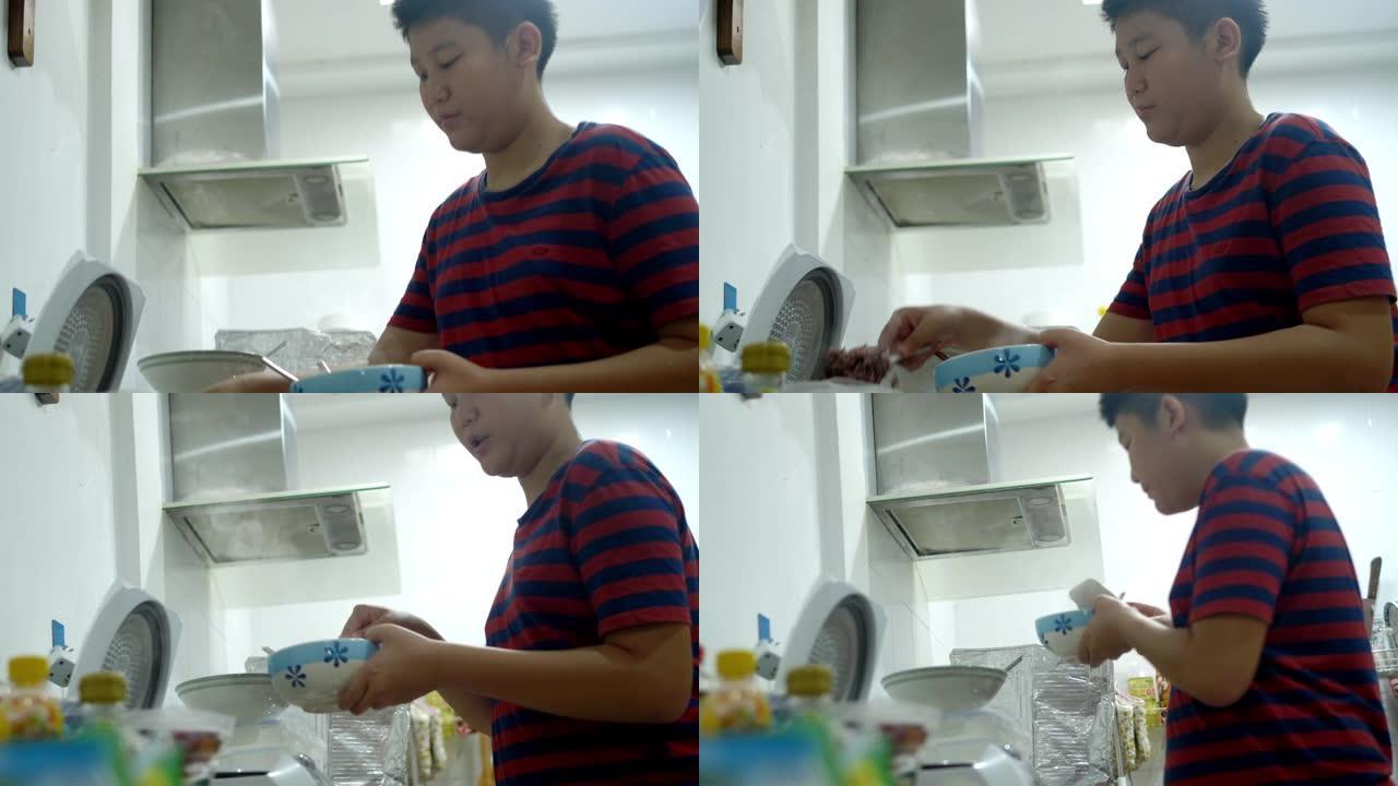 亚洲男孩把米饭放在碗里摆桌子，准备吃。