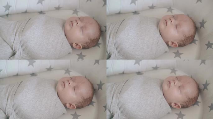 可爱的睡懒觉婴儿儿子裹在薄纱襁褓中