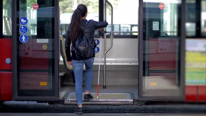 一个年轻的盲人拿着拐杖上了公交车。Indipendence,失明