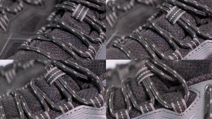 一双带鞋带的旋转黑色跟踪靴的特写镜头。极限运动鞋，青春时尚理念。