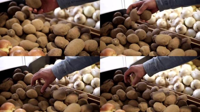 男性双手选择最佳形状的土豆，然后放入透明的塑料包装袋中。购物的人选择漂亮的土豆会添加到包装中。特写