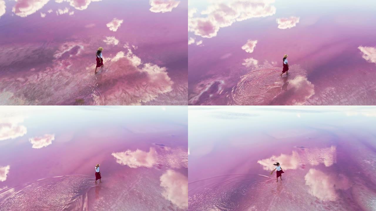 无忧无虑的女人快乐地走在神奇的粉红湖水中