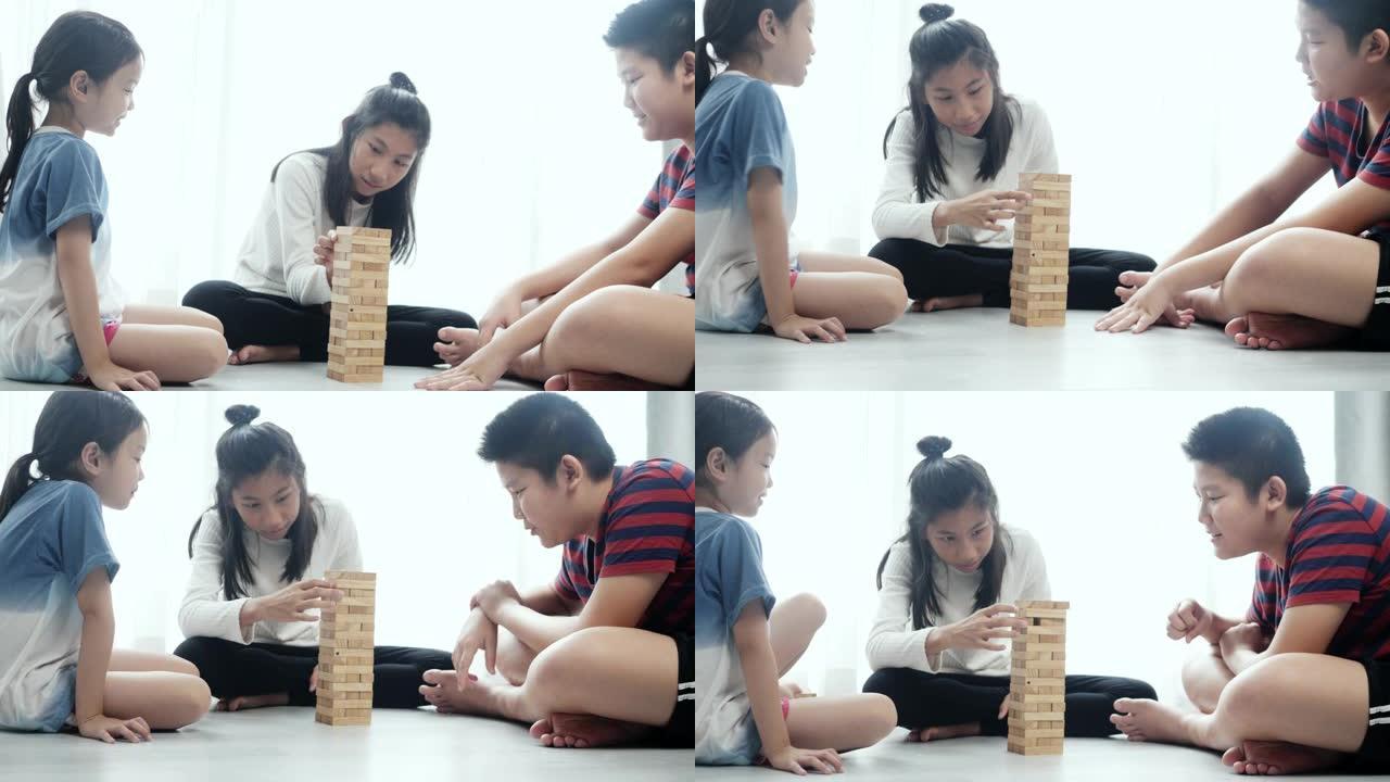 亚洲儿童在家里的地板上一起玩木块拆卸游戏，生活方式理念。