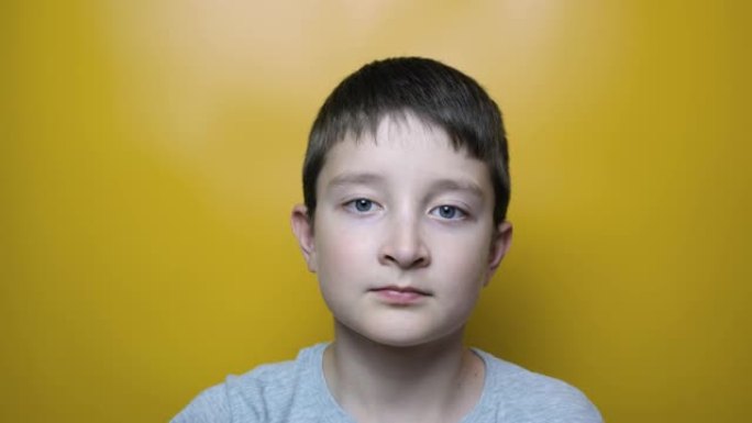 一个可爱的男孩在黄色背景，近视，散光和眼科疾病概念下戴上眼镜的肖像