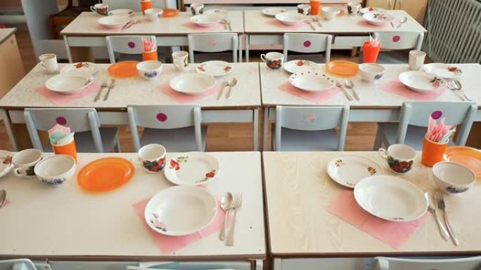 幼儿园里有盘子、杯子、叉子和勺子的餐桌。准备午休。表设置